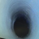Inspection image showing a sewer pipe after a successful drain patch repair, with the hole fully sealed.