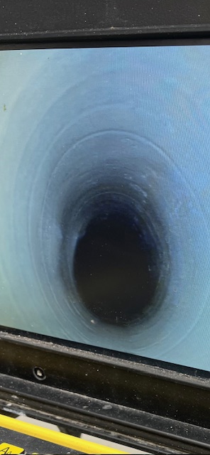 Inspection image showing a sewer pipe after a successful drain patch repair, with the hole fully sealed.